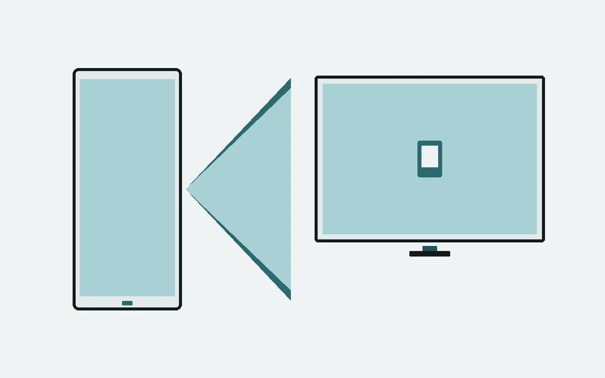 Phone casting a teal beam onto a desktop monitor on mirror-ink paper.